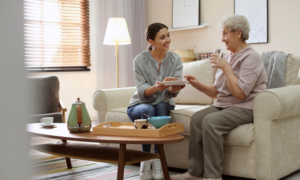 an NDIS registered worker providing a meal to an elderly woman